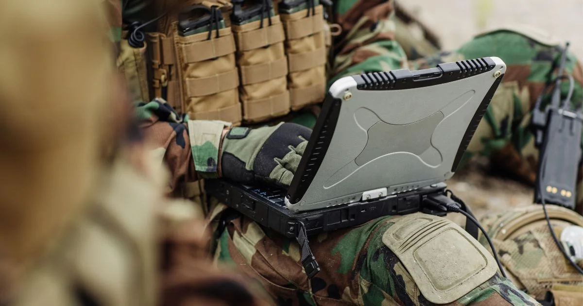 Soldier using rugged laptop in field